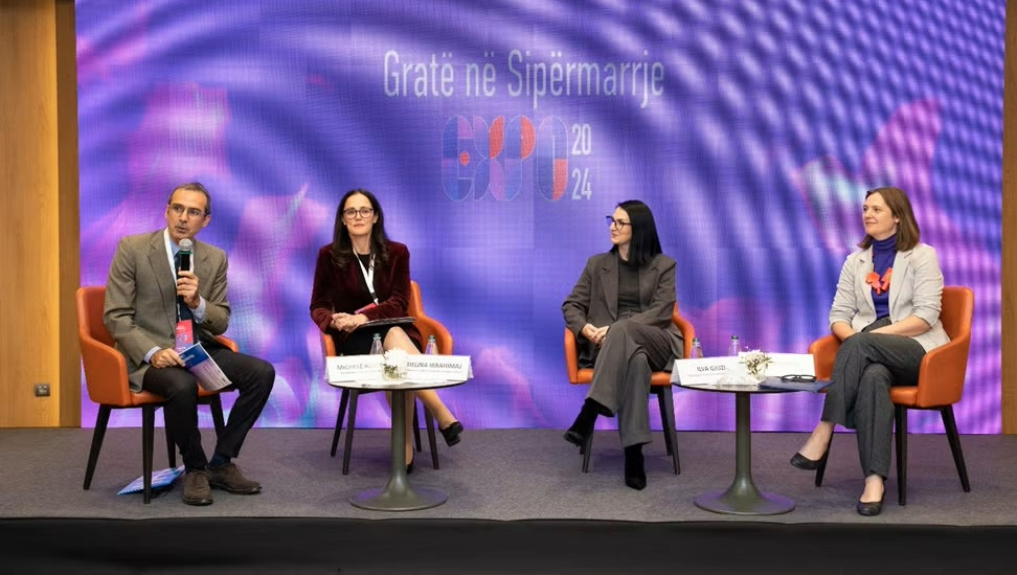 A group of four people sitting in front of a digital screen